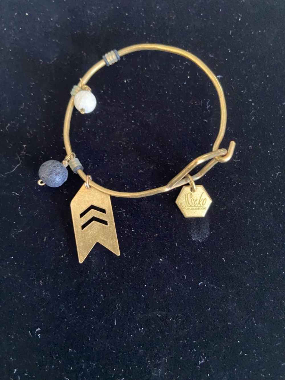 Sseko South America Gold Tone Hammered Wire
Bracelet with Branded Hex
Charm